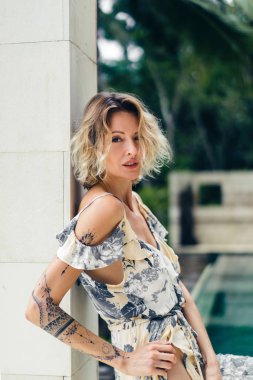 arka plan üzerinde elbise ayakta yüzme havuzlu villa Teras, çekici sarışın kadın yan görünüm