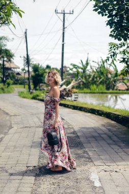 çekici sarışın kadın elbise ayakta sokak, ubud, bali, Endonezya üzerinde yan görünüm