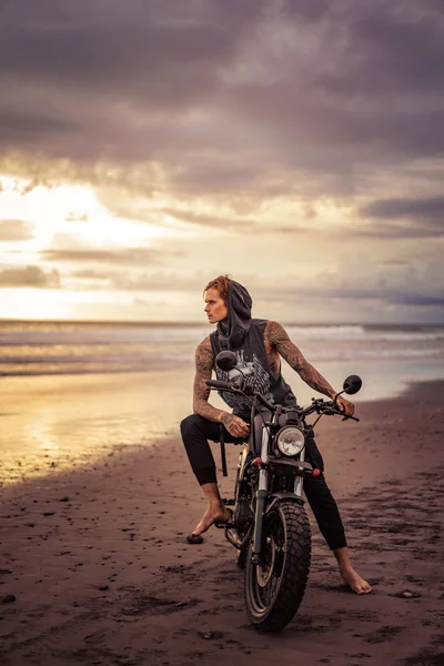 Guapo Hombre Tatuado Sentado Motocicleta Playa Del Océano Mirando Hacia —  Fotos de Stock