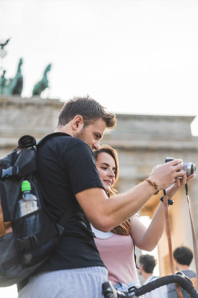  tourists looking at photo camera in front of Brandenburg Gate, Berlin, Germany 