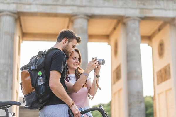 low angle view of woman showing photo camera to boyfriend at Pariser Platz, Berlin, Germany 
