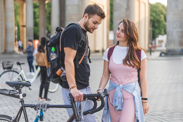 couple of tourists with backpacks and bicycle at Pariser Platz in Berlin, Germany