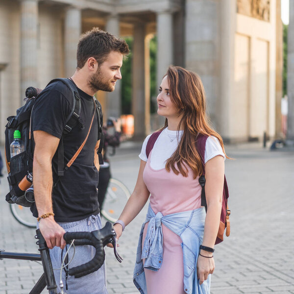 couple of tourists with backpacks looking at each other at Pariser Platz, Berlin, Germany 