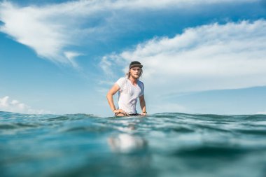 Okyanusu Nusa Dua Beach, Bali, Endonezya sörf tahtası üzerinde oturan erkek sörfçü