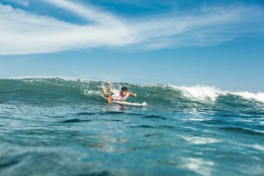 erkek sporcu üzerinde sörf tahtası Nusa Dua Beach, Bali, Endonezya, okyanusta yüzmeye uzak görünümünü