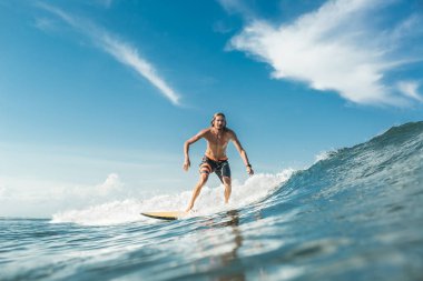 Nusa Dua Beach, Bali, Endonezya, okyanusta dalgaları sürme gömleksiz erkek sörfçü