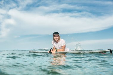 Nusa Dua Beach, Bali, Endonezya sörf tahtası ile okyanusta dinlenme gülümseyen Erkek sörfçü