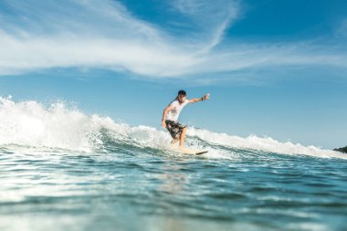 Genç Erkek sörfçü Nusa Dua Beach, Bali, Endonezya, okyanusta dalgaları sürme