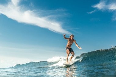 yakışıklı gömleksiz erkek sörfçü Nusa Dua Beach, Bali, Endonezya, okyanusta dalgaları sürme