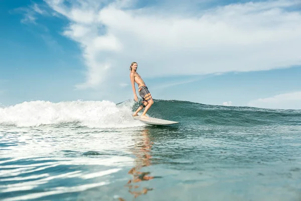 ヌサドゥア ビーチ インドネシアの海で波に乗って上半身裸の男性サーファー — ストック写真