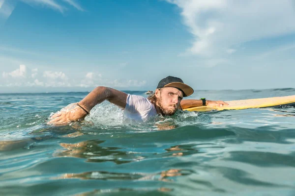 Konzentrierter Männlicher Surfer Schwimmt Mit Surfbrett Ozean Strand Von Nusa — kostenloses Stockfoto