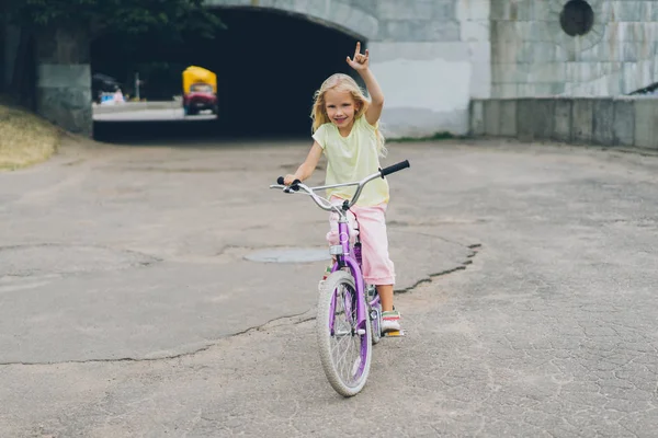 Lächelndes Kind Mit Fahrrad Zeigt Felsschild Auf Straße Stockbild