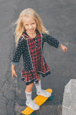 kameraya bakarak ve kaykay Street üzerinde sürme heyecanlı çocuk