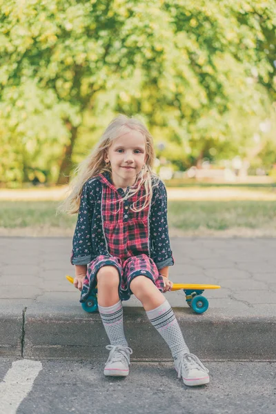 Happy Child Sitting Skateboard Looking Camera Urban Street — Free Stock Photo