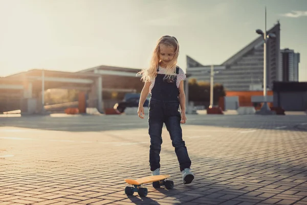 Smiling Adorable Child Standing Skateboard Parking Lot — Free Stock Photo