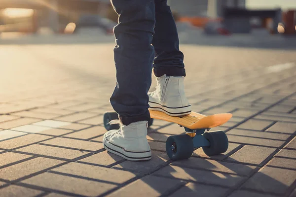 cropped image of little kid standing with penny board at street