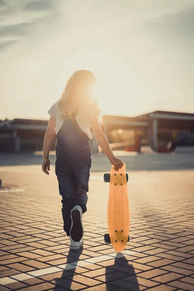 Rear View Little Kid Walking Skateboard Parking Lot Setting Sun — Stock Photo, Image