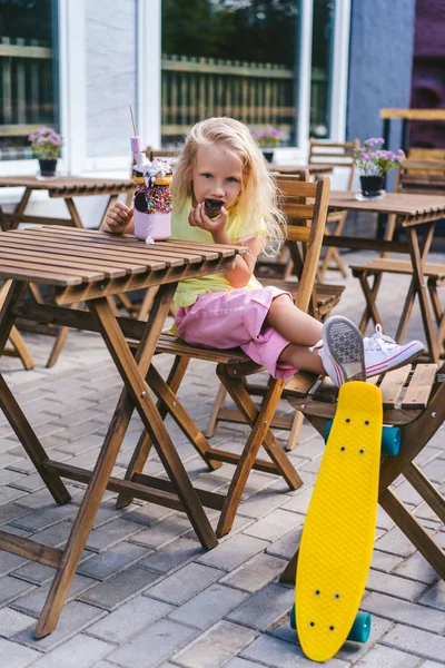 Selective Focus Little Child Eating Dessert Table Skateboard Cafe — Free Stock Photo