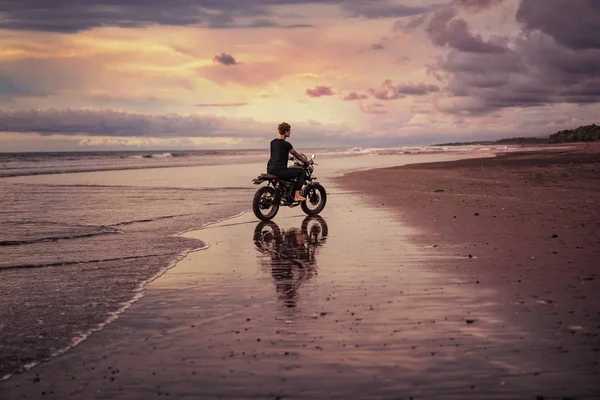 Vue latérale de l'homme à moto sur le bord de la mer — Photo de stock