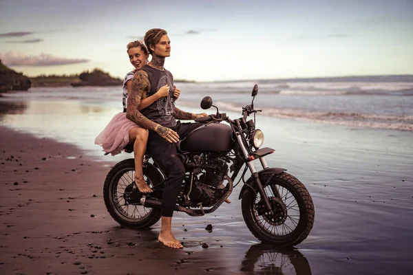 Sorrindo namorada abraçando namorado na motocicleta na praia do oceano — Fotografia de Stock