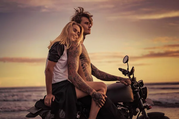 Happy girlfriend leaning on boyfriend shoulder on motorcycle on ocean beach — Stock Photo