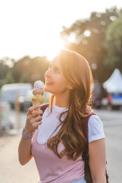 Vista laterale di sorridere giovane donna mangiare gelato — Foto stock