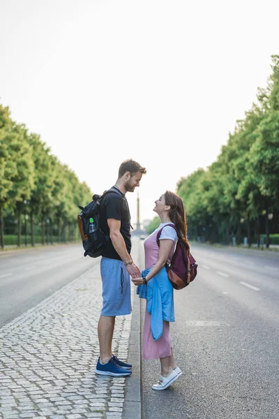 Side view of couple holding hands and looking at each other at street in Berlin, Germany — Stock Photo