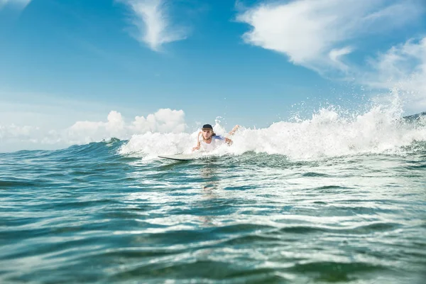 Male surfer swimming on surfing board in ocean at Nusa Dua Beach, Bali, Indonesia — Stock Photo