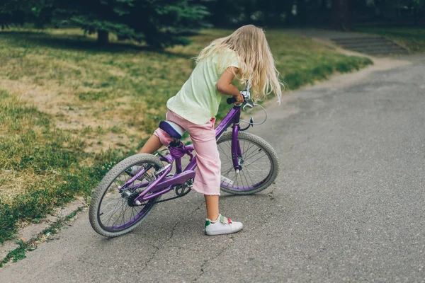 Side view of cute kid with bicycle on street — Stock Photo