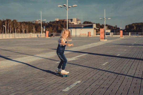 Щаслива маленька дитина катається на скейтборді на парковці — стокове фото