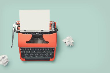 red vintage 60s / 70s typewriter with blank page and paper balls on a bright green desk, retro workspace or office design elements clipart