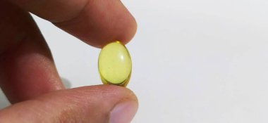 Beyaz arka planda balık yağı ya da balık yağı kapsülleri var. Omega 3 yağ asitleri, EPA, DHA içerir.