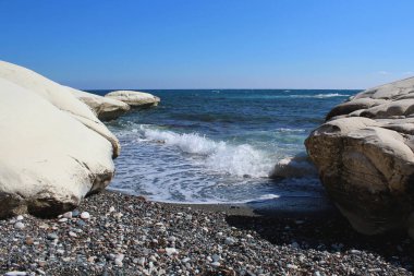 Kayaların arasında beyaz köpüklü deniz dalgaları