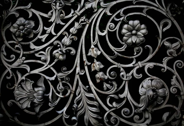 Çiçek desenleri şeklinde dövülmüş metal kafes.