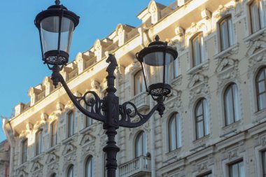 St. Petersburg 'daki Çarlık döneminden kalma güzel bir binanın arka planında fenerle süslenmiş bir sokak lambası.