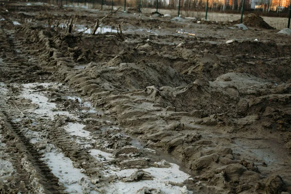 Toprak, çimento, kum, su ve su birikintileriyle inşaat atığı yağmurdan sonra kapanıyor.