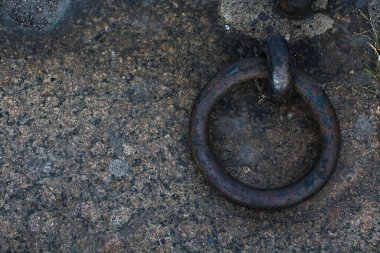 Gri granitte dövülmüş metal halka