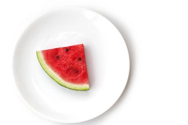 Beyaz bir tabakta sulu olgun kırmızı karpuz dilimi