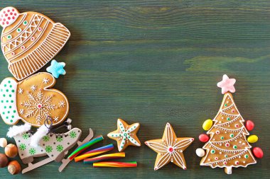 Noel zencefilli, farklı tatlılar, fındık ve süs eşyaları yeşil renk ahşap bir masa üzerinde yalan. Renk foto.