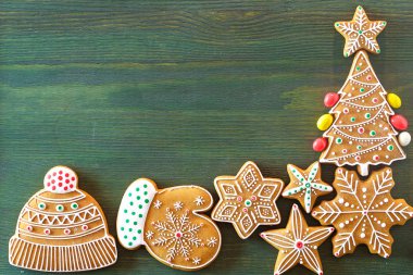 Noel zencefilli, farklı tatlılar, fındık ve süs eşyaları yeşil renk ahşap bir masa üzerinde yalan. Renk foto.