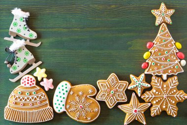 Noel zencefilli, farklı tatlılar, fındık ve süs eşyaları yeşil renk ahşap bir masa üzerinde yalan. Renk foto.