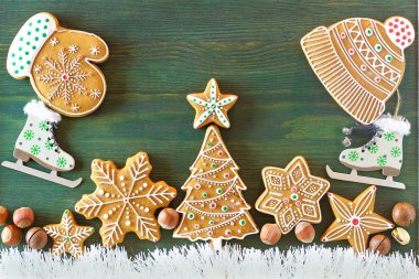 Noel zencefilli, farklı tatlılar, fındık ve süs eşyaları yeşil renk ahşap bir masa üzerinde yalan. Renk foto.