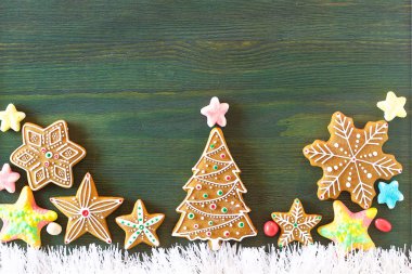 Noel zencefilli, farklı tatlılar, fındık ve süs eşyaları yeşil renk ahşap bir masa üzerinde yalan. Renk foto.