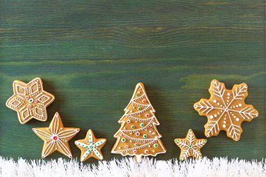 Noel zencefilli, farklı tatlılar, fındık ve süs eşyaları yeşil renk ahşap bir masa üzerinde yalan.