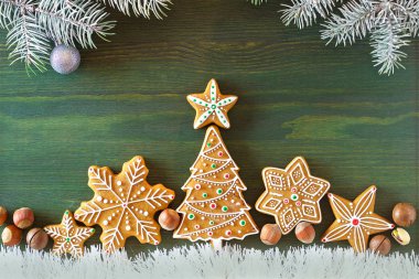 Noel zencefilli, farklı tatlılar, fındık ve süs ler ladin dalları ile yeşil renk ahşap bir masa üzerinde yalan