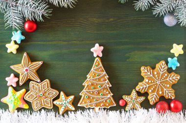 Noel zencefilli, farklı tatlılar, fındık ve süs ler ladin dalları ile yeşil renk ahşap bir masa üzerinde yalan