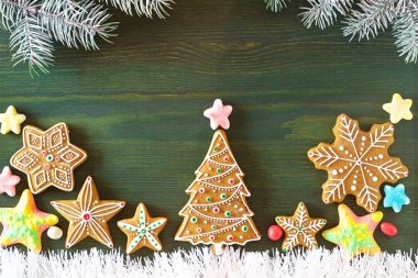 Noel zencefilli, farklı tatlılar, fındık ve süs ler ladin dalları ile yeşil renk ahşap bir masa üzerinde yalan