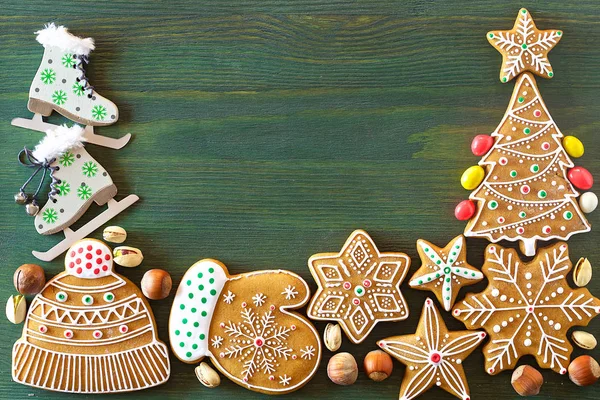 Noel zencefilli, farklı tatlılar, fındık ve süs eşyaları yeşil renk ahşap bir masa üzerinde yalan. Renk foto.