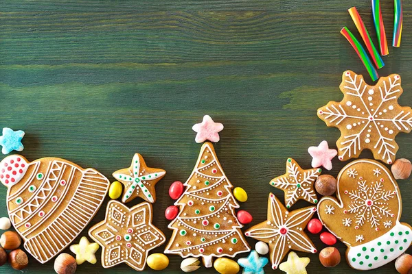 Noel zencefilli, farklı tatlılar, fındık ve süs eşyaları yeşil renk ahşap bir masa üzerinde yalan. Renk foto.