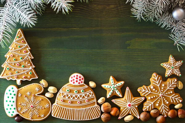 Noel zencefilli, farklı tatlılar, fındık ve süs ler ladin dalları ile yeşil renk ahşap bir masa üzerinde yalan